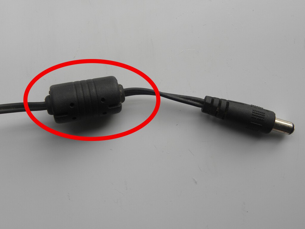 Aquele "cilindro" no cabo do seu notebook não está ali de enfeite: o "escudo invisível" que salva a vida do seu computador todos os dias