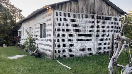 A vista externa da "Casa de Sal" mostra as paredes, construídas com milhares de garrafas de vidro — aparentemente vazias — dispostas verticalmente e argamassa branca. (Crédito da imagem: Edna Dantas)