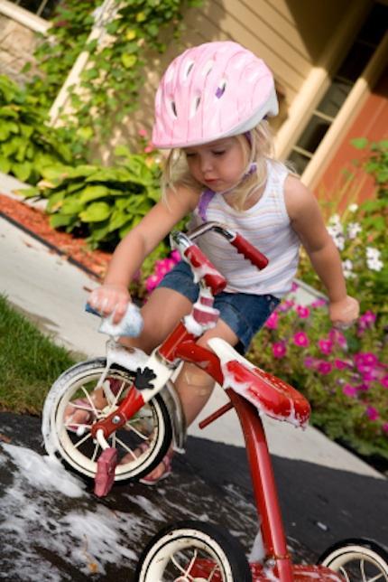 niña limpiando bicicleta