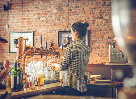 Mujer sirviendo una cerveza en un bar