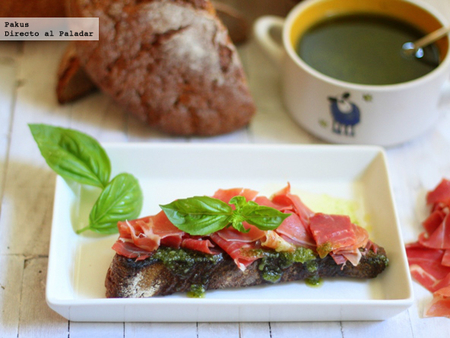 Tostas de pan de centeno con pesto y lascas de jamón. Receta