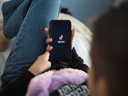 Imagem foca na tela de um telefone conectado no TikTok na mão de um adolescente