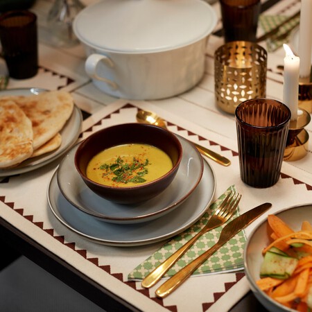 Mesa con vajilla azul y crema de verduras