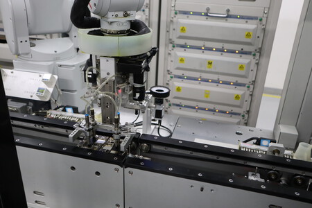 Un brazo robótico ejecuta unas pruebas en una placa base | Imagen: Xataka