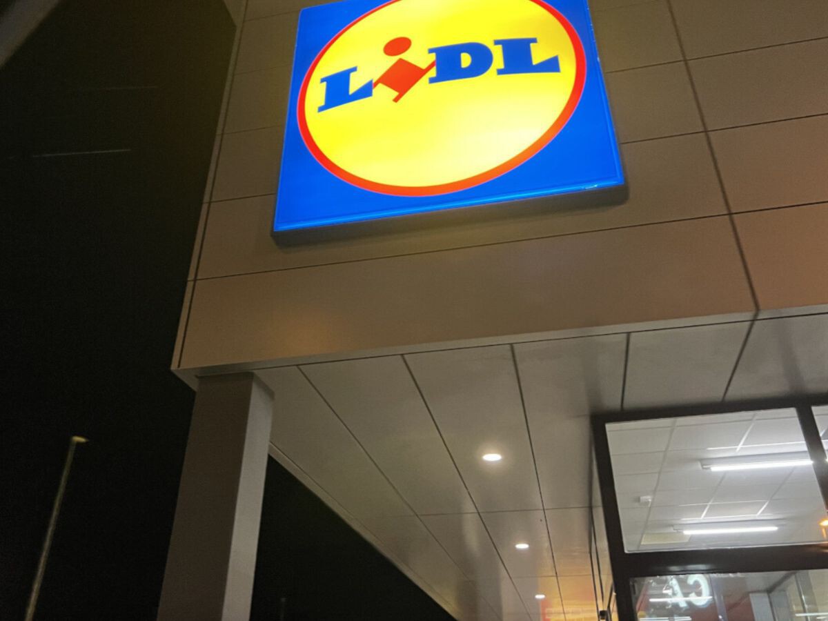 Entrada de un supermercado con carteles de ofertas y promociones de precios.