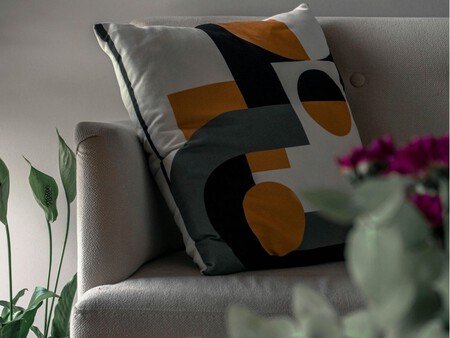 Cojín con tonos mostaza y verdes, y formas geométricas.