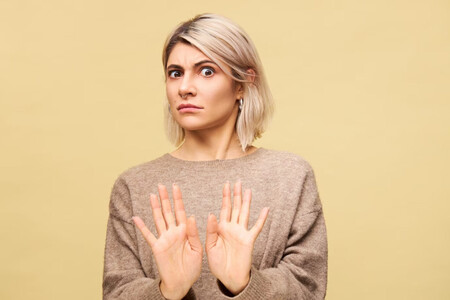 Mujer rubia diciendo que no con un gesto
