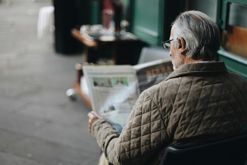 Foto de un hombre leyendo el periódico en la calle