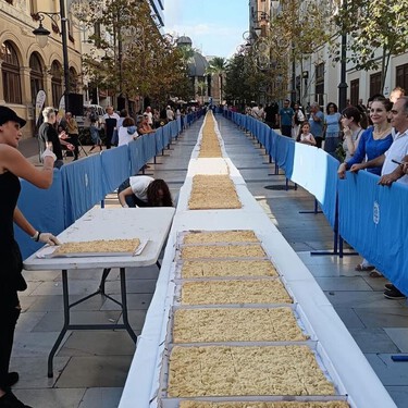 Los panaderos de Alicante fabrican la coca de mollitas más larga del mundo: 108 metros y más de 9.000 raciones