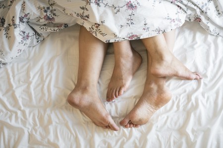 Pies de una pareja en la cama