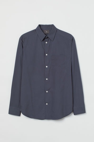 Camisa de algodón con cuello inglés y tapeta lisa. Modelo con bolsillo superior abierto, mangas largas con perilla y botón, cierre ajustable en los puños, canesú en la espalda y bajo redondeado.
