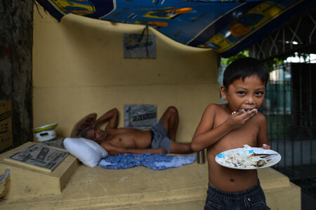criança comendo com a mão comida no prato. Créditos: banco de imagens