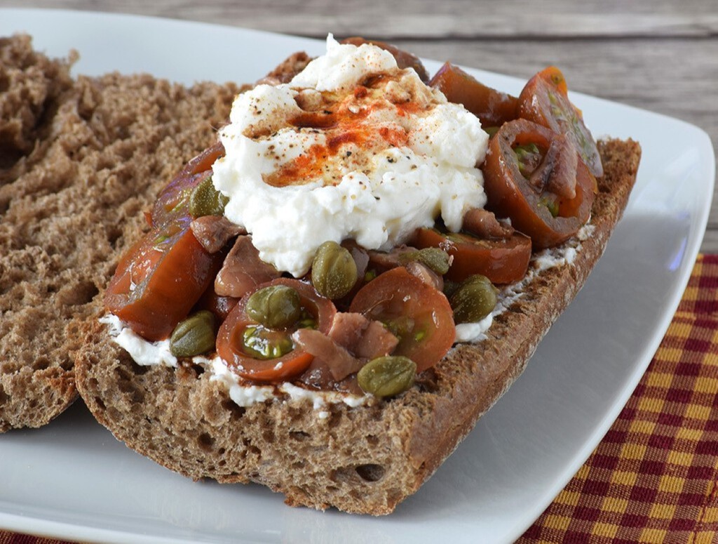 Bocadillo de tomatitos marinados con anchoas y queso ricotta. Receta