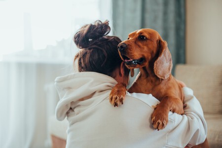 Un tutor abrazando a su perro