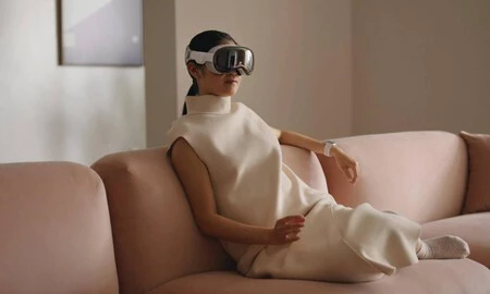 Mujer usando las Vision Pro en un sofá Mujer usando las Vision Pro en un sofá