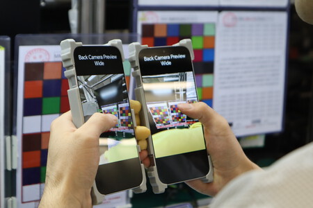 Un "Consumer Experience Officer" comprueba la cámara de los móviles en el tramo final de la línea de fabricación | Imagen: Xataka