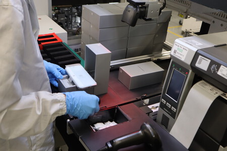 El penúltimo operador introduce el móvil en la caja y la coloca en la zona de envasado | Imagen: Xataka