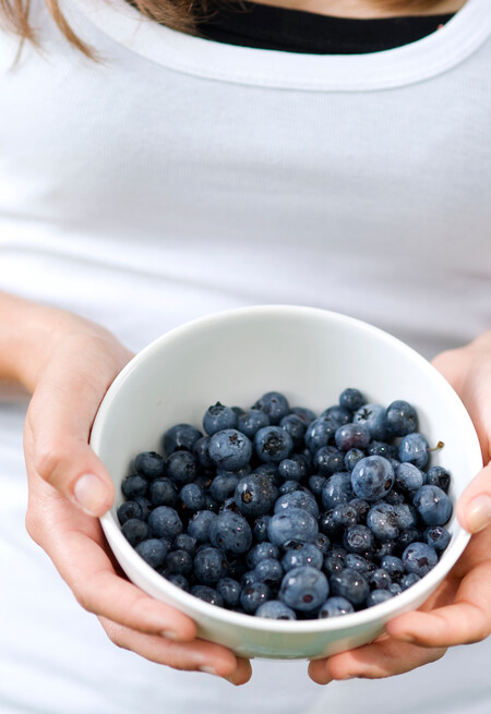 Young Woman Holding Bowl Filled Blueberries