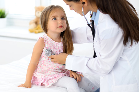 Médico auscultando a una niña