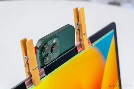 MacBook の上部フレームから 2 つのクランプと冷凍バッグで保持されている iPhone