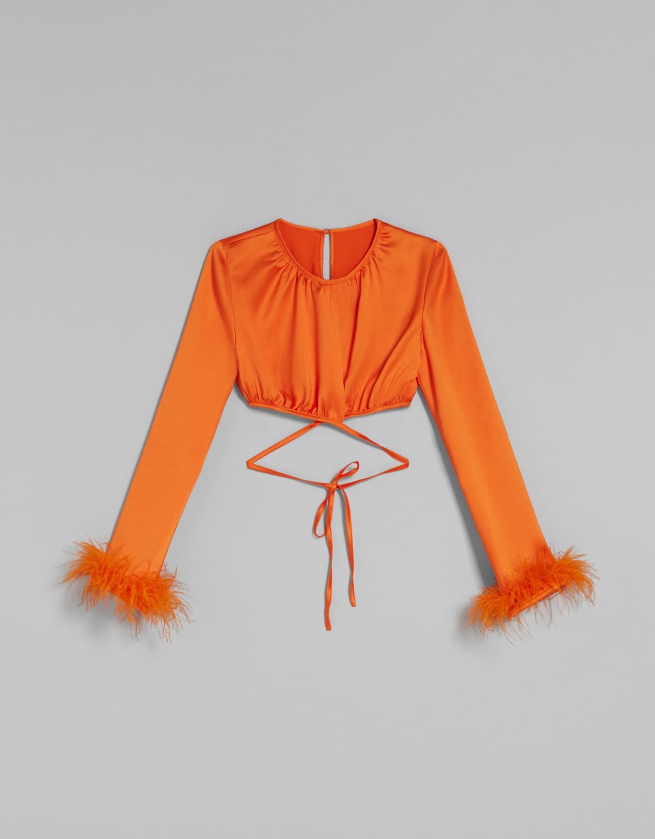 Blusa cropped satinada con plumas
