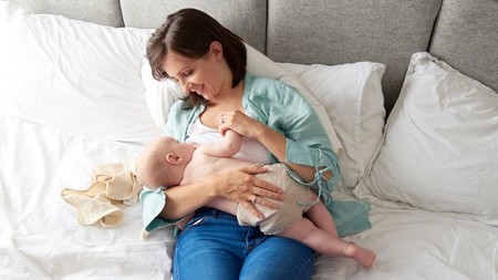 Mamá dando de comer al bebé en posicion Acostada Reclinada