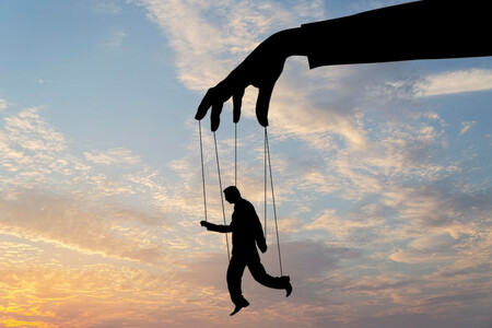 Silueta de un hombre con cuerdas como las de una marioneta, que llevan hasta una mano. Fiel reflejo de cómo el  marketing y la manipulación nos afectan.
