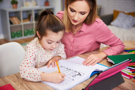 Young Woman Helping Girl With Homework 1