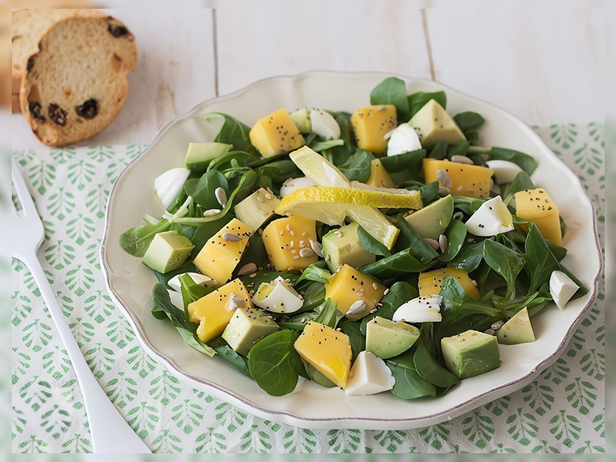 Ensalada de canónigos con aguacate, mango y queso fresco en un plato blanco