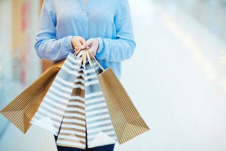 Una mujer con muchas bolsas de compra en la mano