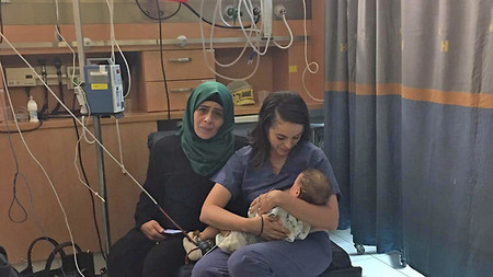 Una enfermera judía amamanta a una bebé palestina cuya madre resultó herida en un accidente