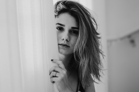 Chica adolescente tras cortina