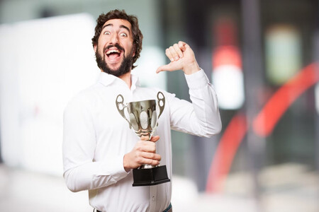 Hombre con barba y trofeo señalándose a sí mismo