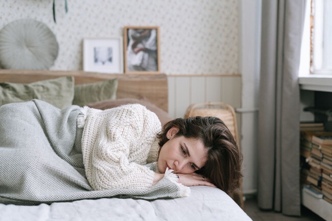 Mujer tumbada en la cama con dolor