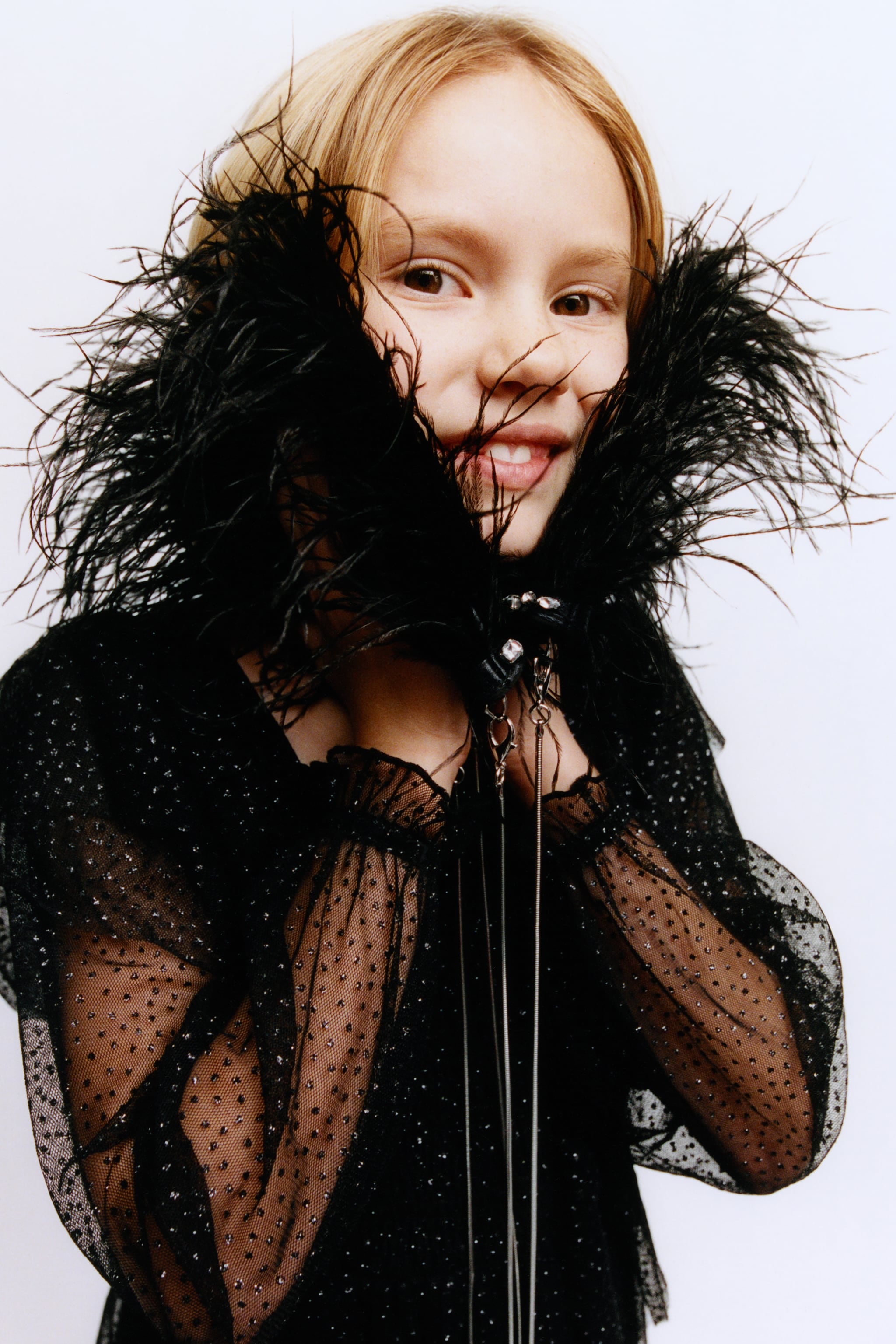 Vestido de tul cuello recto y manga larga acabado gomas. Detalle nido de abeja en pechera. Aplique volantes y brillos.