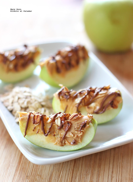 Gajos de manzana con crema de cacahuate, avena tostada y chocolate. Receta para niños
