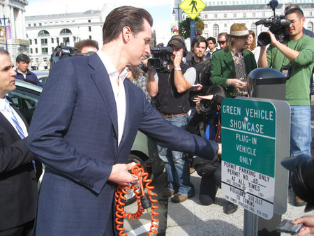 Político inaugurando punto de recarga eléctrico