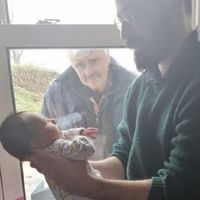 La conmovedora foto viral en la que un abuelo conoce a su nieto recién nacido en tiempos de coronavirus 