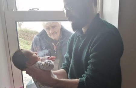 La conmovedora foto viral en la que un abuelo conoce a su nieto recién nacido en tiempos de coronavirus