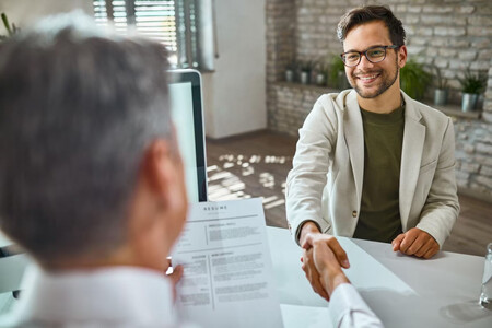 Dos personas dándose la mano en una entrevista de trabajo