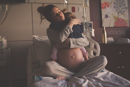La emotiva foto de una madre abrazando a su hija antes de darle la bienvenida a un nuevo bebé