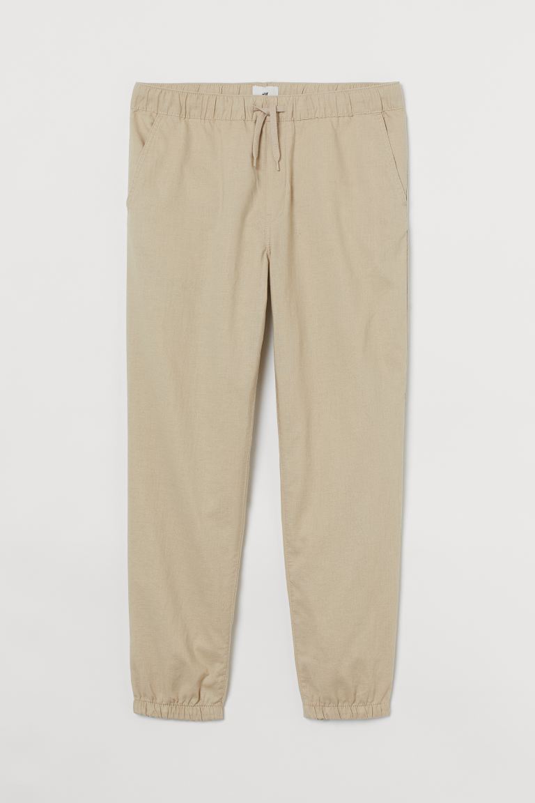 Joggers de algodón y lino con cordón de ajuste en la cintura, bolsillos al bies y bolsillos insertados detrás. Elástico revestido en cintura y bajo. Corte estándar – ajuste clásico para una silueta recta y cómoda con una buena libertad de movimientos.