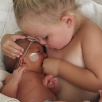 El tierno vídeo de una niña pretendiendo "amamantar" a su hermana recién nacida para calmarla