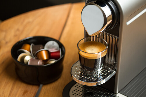 máquina Nespresso ao lado de cápsulas de café. Créditos: banco de imagens