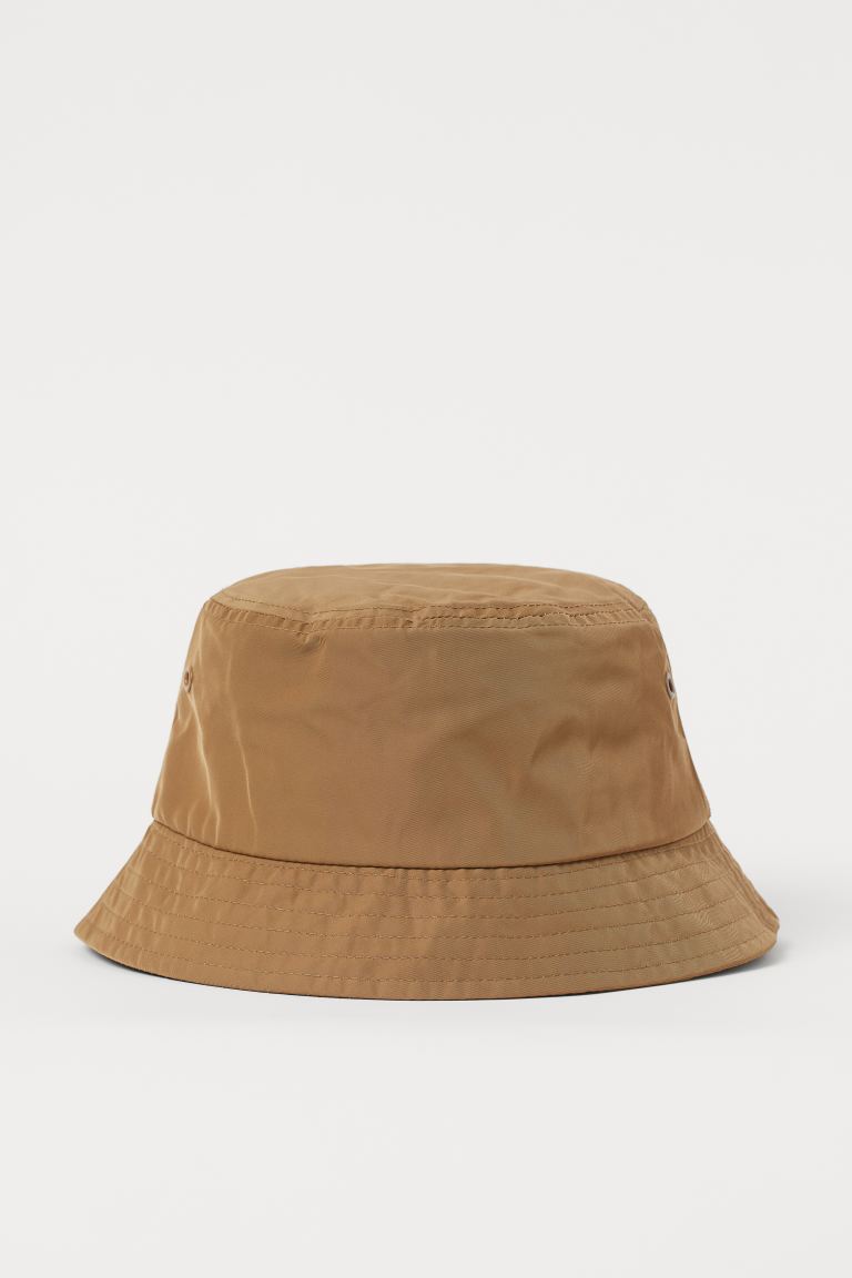 Sombrero bucket tejido con ligero brillo. Cinta antisudor y ojales de metal en cada lado.