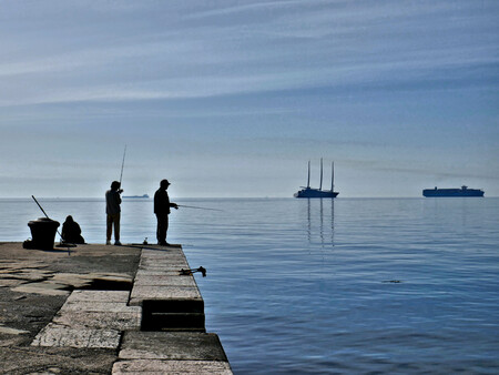 Pescadores en Trieste con el Sailing Yacht A al fondo