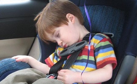 Niño durmiendo en el coche