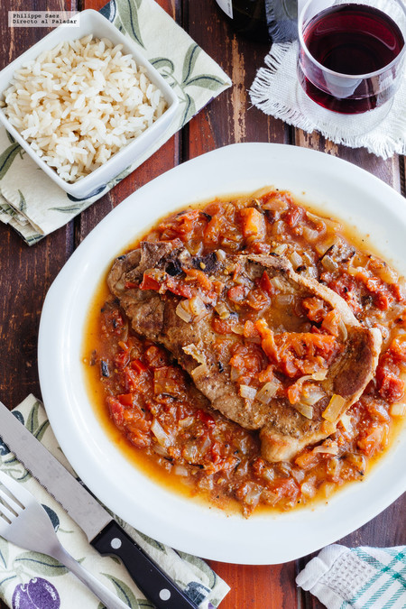 Chuletas de cerdo en salsa de vino blanco con cebolla y jitomate. Receta rápida
