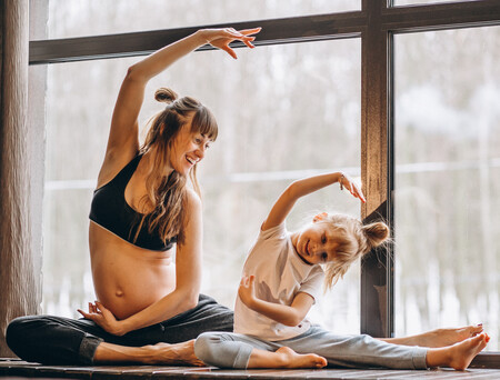 Pregnant Mopther Doing Yoga With Little Daughter