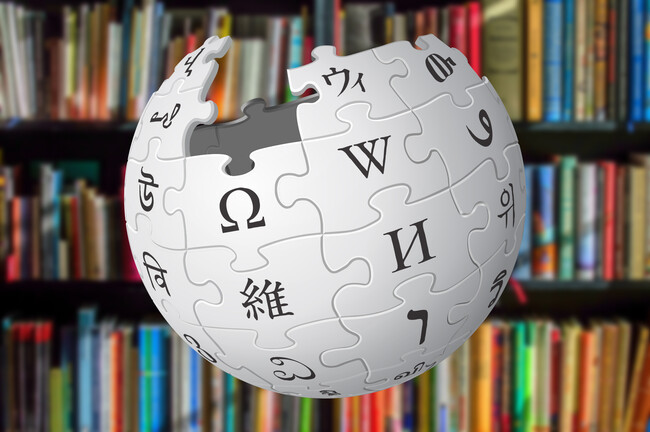 Logo de Wikipedia sobre una imagen de libros